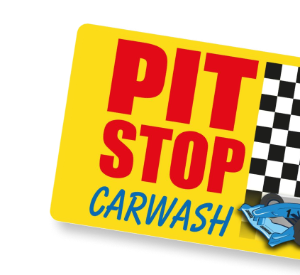 Geel bord met de tekst "Pit Stop Carwash" en een zwart-wit geblokt patroon.